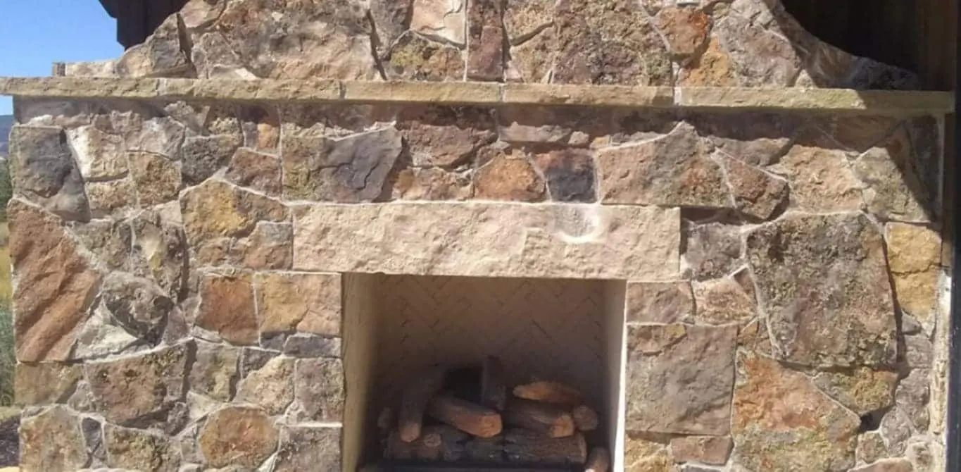 Outdoor stone fireplace for a backyard patio